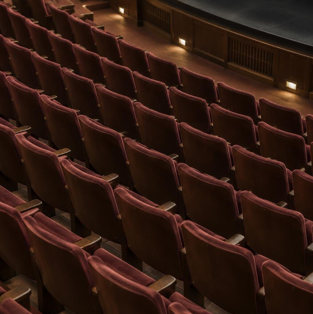 Empty theatre seats in soft ambient light